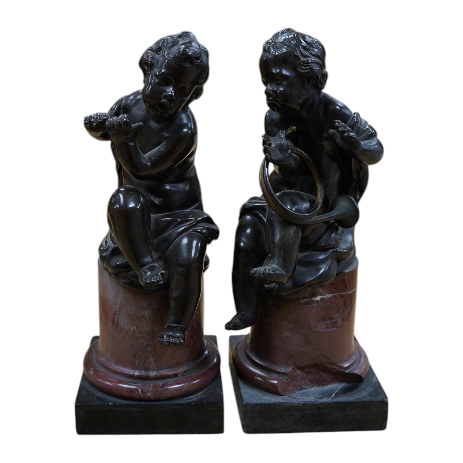 A pair of 19th century French bronze figures of children playing instruments, raised on rouge marble columns, 23cm high. Condition - poor